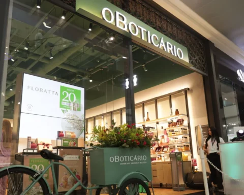 Storefront of O Boticário in a mall, mint-green delivery bike with flowers parked outside and interior shelves visible behind glass door