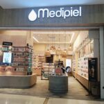 Medopiel storefront interior with curved beige counter and shelves of skincare products inside a well-lit beauty shop.