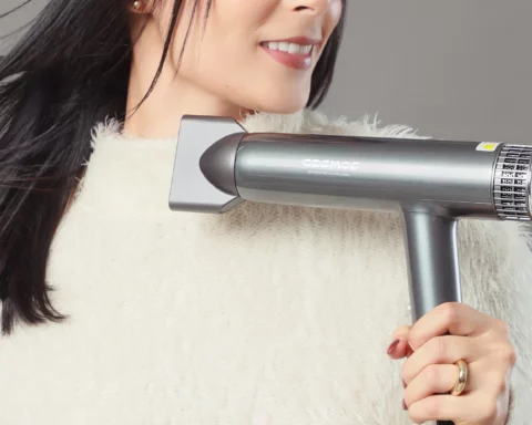 Woman holding a hair dryer in a gray advertisement banner, with white text: 'SAGITTA Potencia inteligente para un acabado superior' and a neon yellow 'LÍNEA PROFESIONAL' badge.