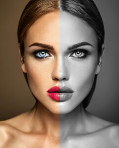 Split-image portrait of a woman: left side in color with blue eye and pink lips, right side in grayscale.